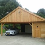 Ruime houten carport met fietsenschuurtje